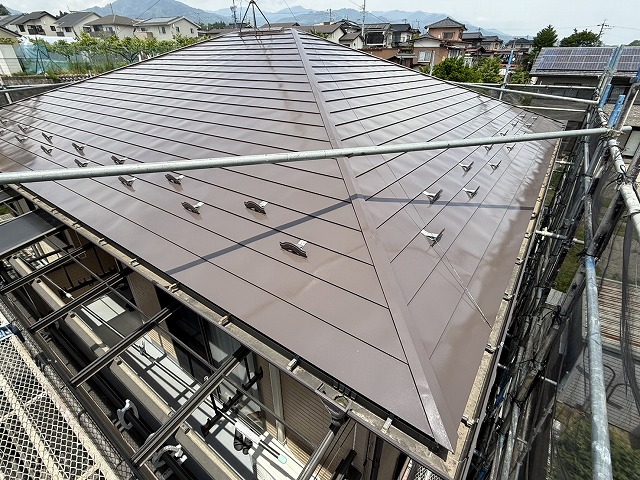 飯田市で濃いブラウン色を用いた金属屋根塗装上塗り、落ち着きのある上品な仕上がりに