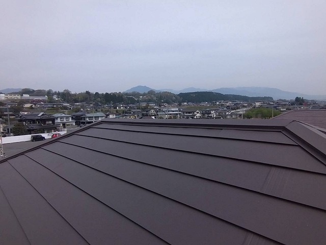 飯田市でSGL鋼板屋根を用いたカバー工事、棟部への板金役物設置の様子