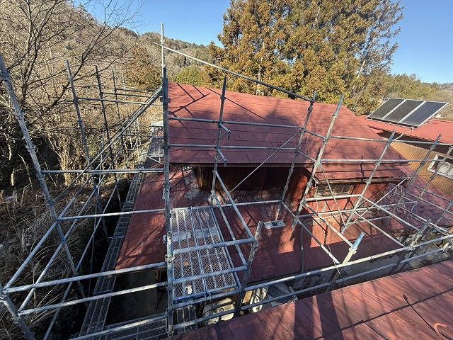 屋根カバー工事のために住宅外周に足場を組み立てている施工の様子