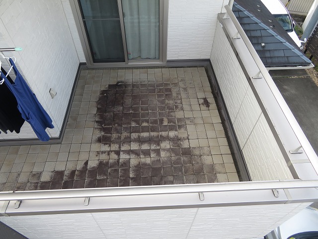 現場調査でベランダのタイルに汚れや苔などが付着している状況