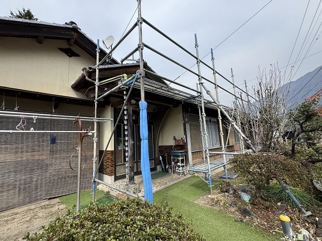 屋根カバー工事を行う住宅玄関前の建地に対するクッション養生