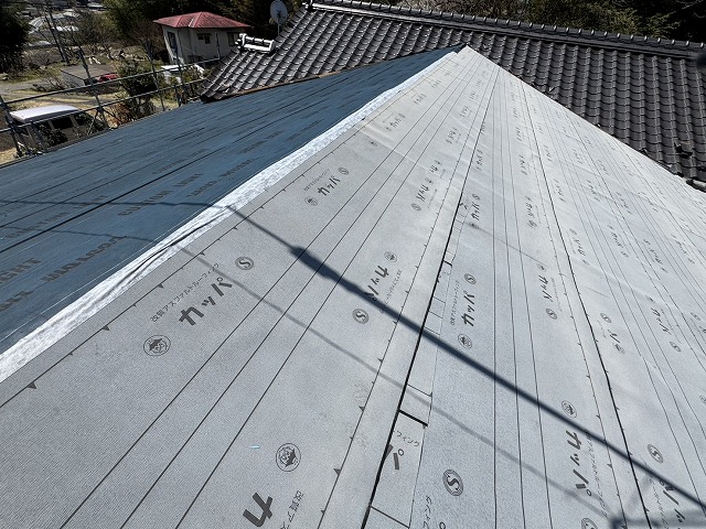 戸建て住宅の屋根カバー工事の防水シート敷設と棟部への防水テープ貼り付け