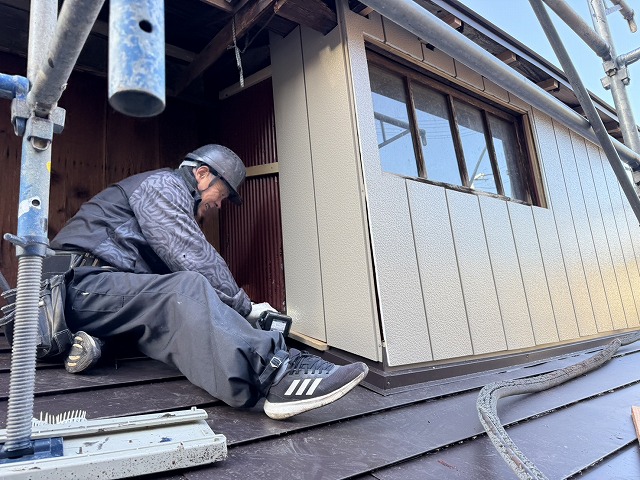 金属サイディングを胴縁に固定しながら本体張りを進めている施工状況