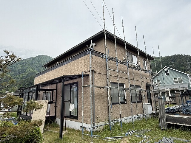 足場資材を積んだ車両を住宅前に横付けした様子