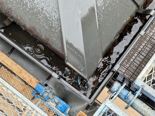 洗浄前の雨樋に苔や落ち葉が堆積して排水性が損なわれている状況