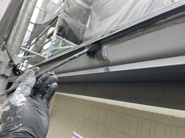 住宅外壁塗装工事の軒樋に対するハケ塗装の様子