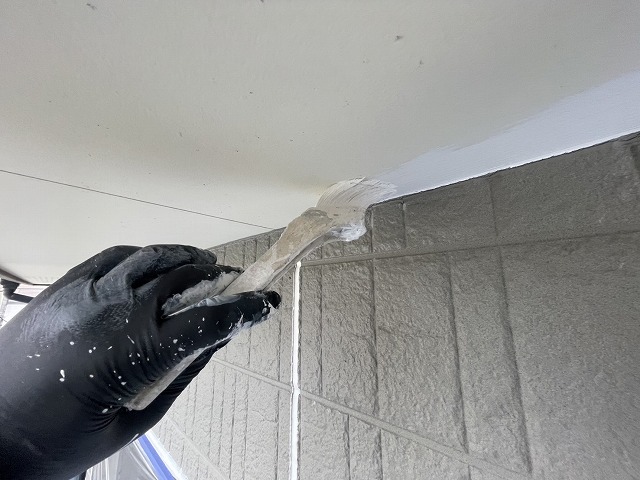 住宅外壁塗装工事の軒天と外壁との取り合い部へのハケ塗り