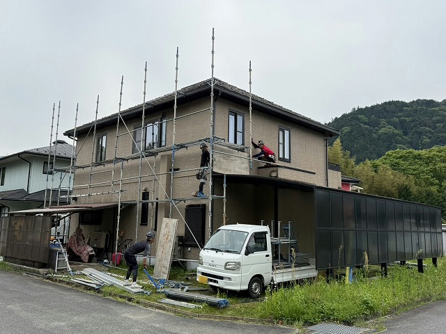 足場の金属部材を組み立てている足場職人の様子
