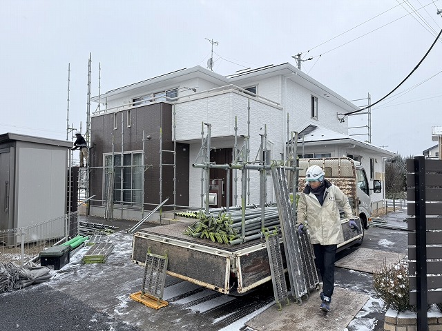 サイディング外壁塗装工事が完了して解体した足場資材を車両に積み込んでいる様子