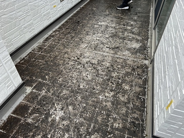 ベランダ防水工事を行う住宅のベランダ床面に汚れや苔などが激しく付着している様子