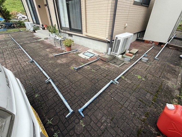 金属屋根塗装工事で足場部材を建物まわりに配っている様子