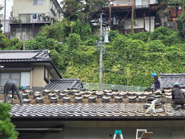 屋根葺き替え工事で取り外した瓦を積み上げて仮置きしている様子