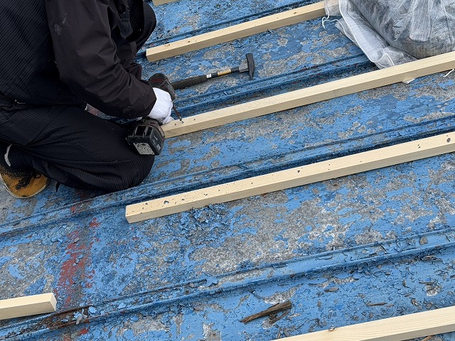 戸建て住宅屋根カバー工事で既存金属屋根に垂木を固定している様子