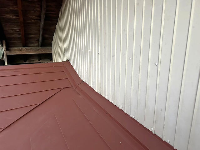 住宅屋根カバー工事の壁取り合い部の雨押え板金固定状況