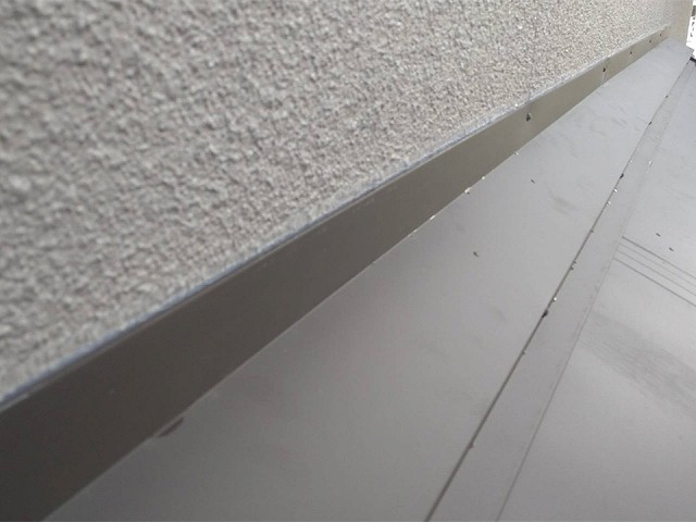 屋根カバー工事で雨押え板金と外壁との取り合い部へコーキング処理