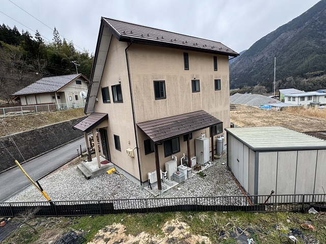経年劣化による金属屋根塗装工事を行う招き屋根住宅の外観