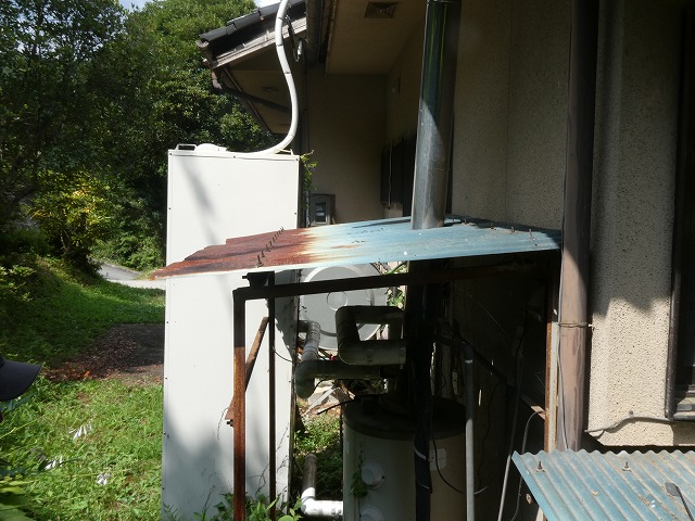 給湯設備を覆う波板屋根にサビによる腐食が進んだ状態